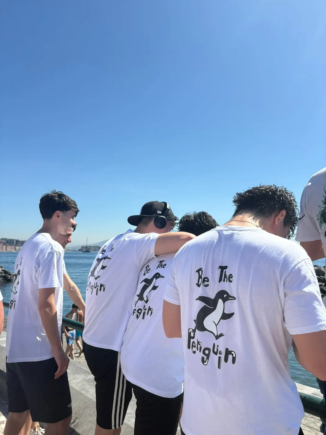 Un gruppo di runner con le magliette Be The Penguin sul lungomare, con il Castel dell’Ovo sullo sfondo
